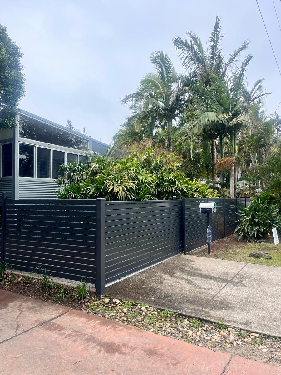 Charcoal horizontal aluminium slat fence with a matching slat sliding driveway gate