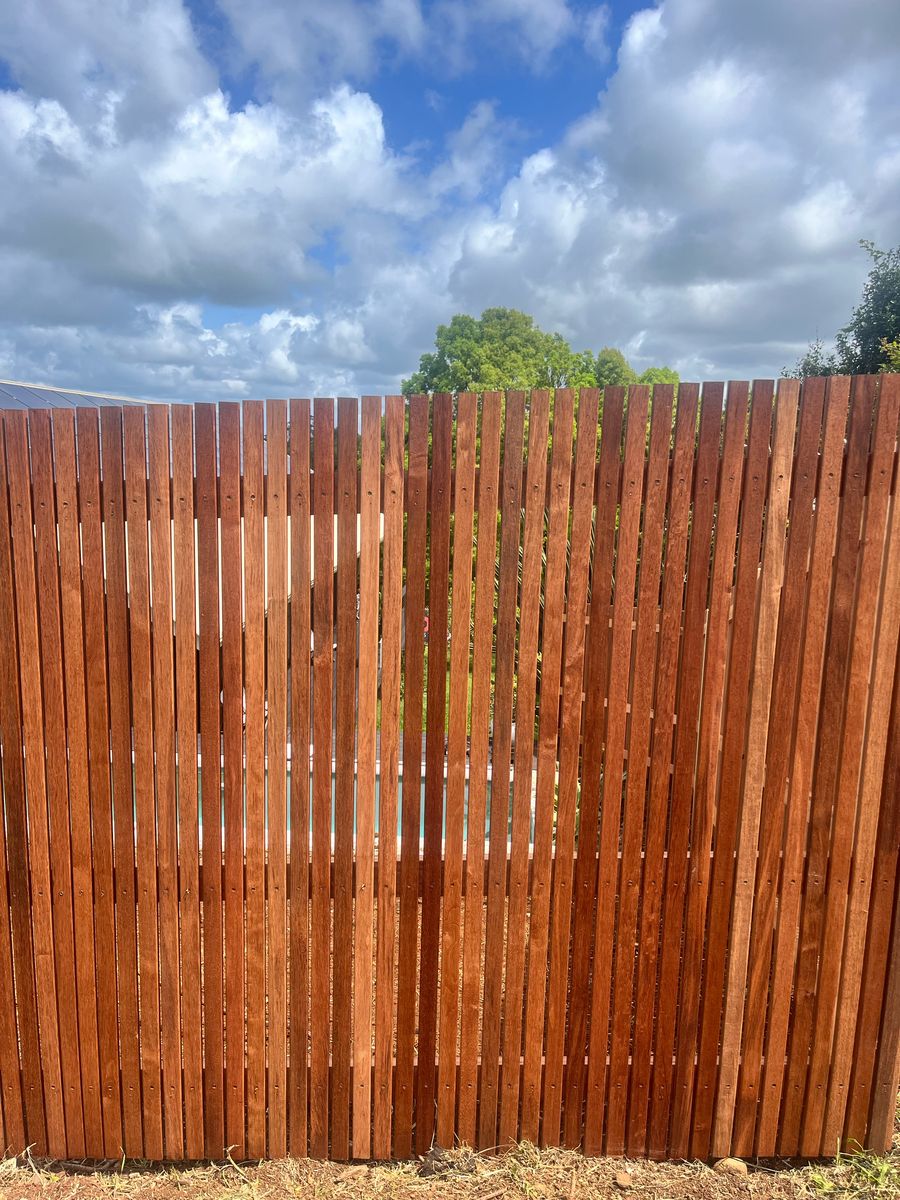 Vertical hardwood batten fence with gaps between the battens