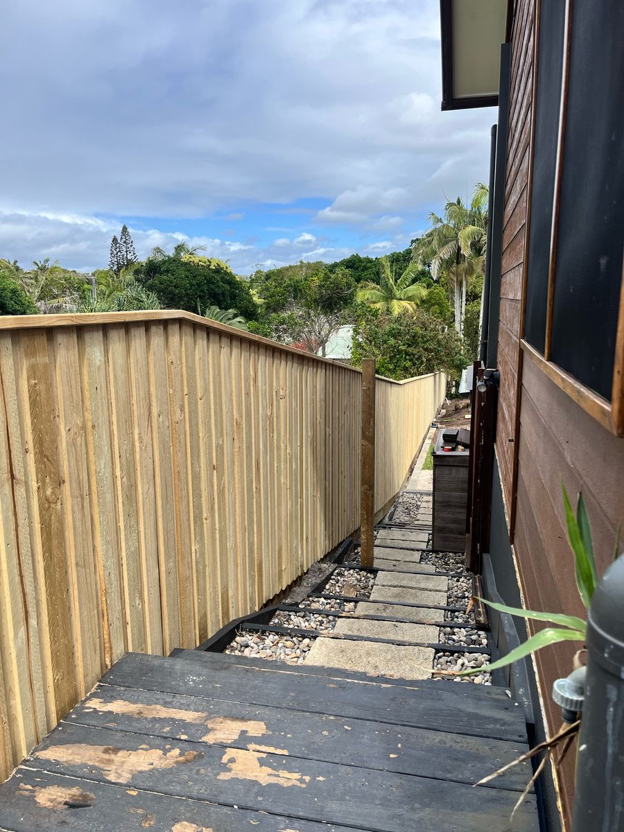 Lapped and capped treated pine paling fence along a side path